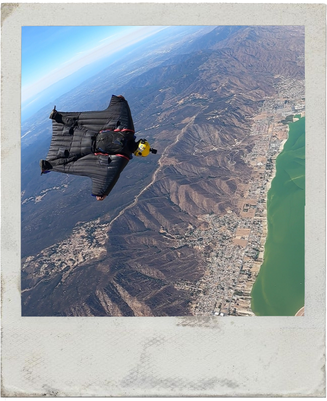 Ânderson Q. wingsuit flying over scenic mountains - extreme sports athlete, skydiving instructor, and AKASHA Foundation decentralized internet builder